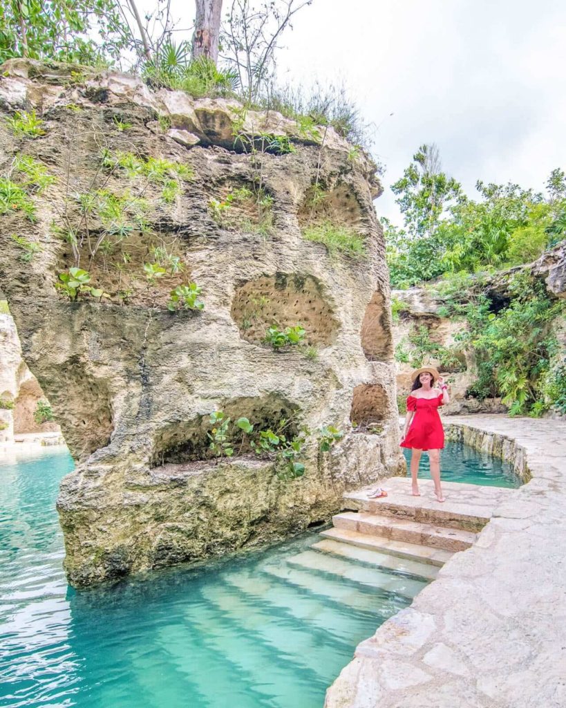 Girl walking around landscape of Hotel Xcaret Mexico by water