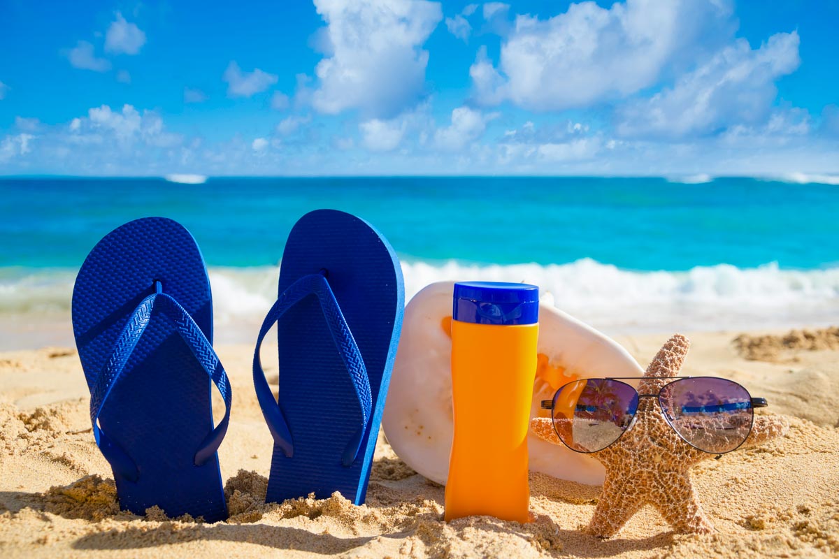 Sunscreen and flip flops along a beach in Hawaii