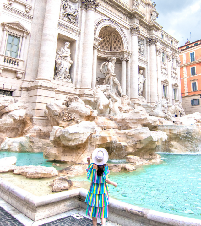 Woman standing in front of the Trevi Fountain in Rome, Italy