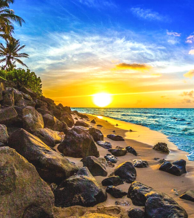 Beautiful sunset on Oahu's North Shore, showing sun setting over the ocean next to beach