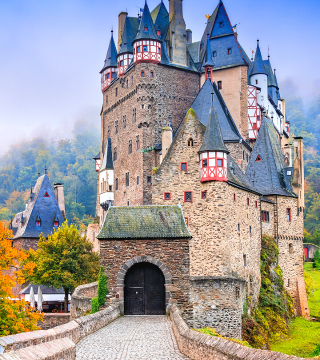 View of the front entrance of Eltz Castle, surrounded by fall colors in autumn
