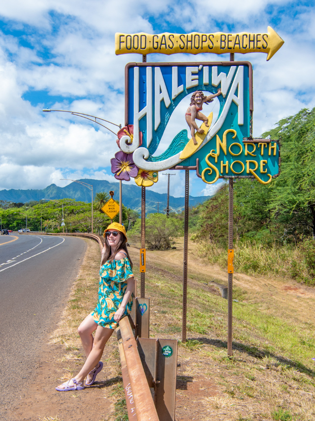 Woman posing in front of famous surfer sign in the town of Haleiwa on the North Shore of Oahu